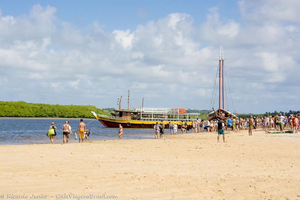 Imagem de turistas aguardando os barcos de passeio na Praia de Santo André.